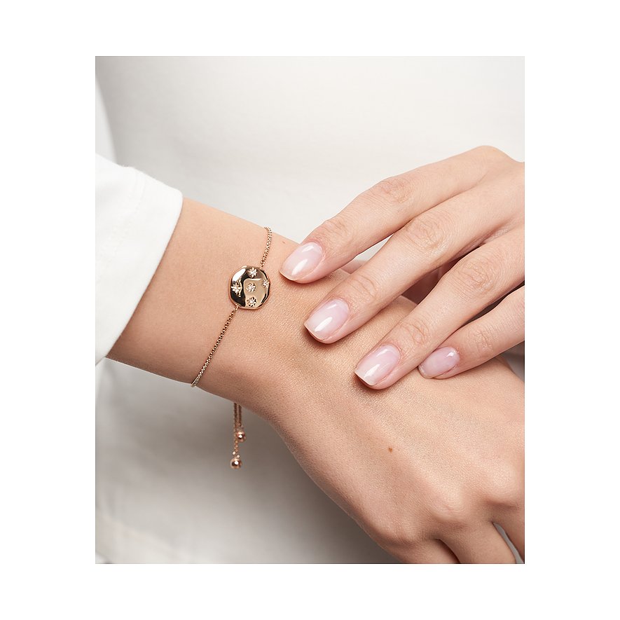 Dieses rosévergoldete Tamaris Edelstahl-Armband mit Zirkonia-besetztem Anhänger ziert ein Handgelenk.
