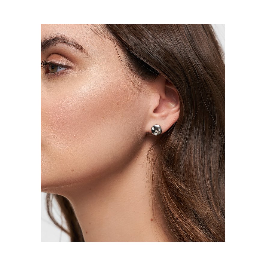 Boucle d'oreille Tamaris en acier inoxydable argenté avec zircones colorées, portée à l'oreille d'une femme.