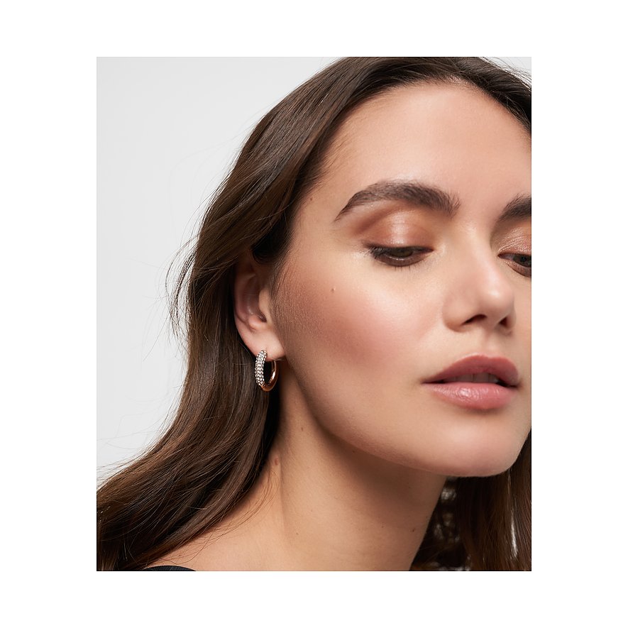 Närbild på kvinna som bär ett Tamaris öronsmycke i rostfritt stål med glasstenar.