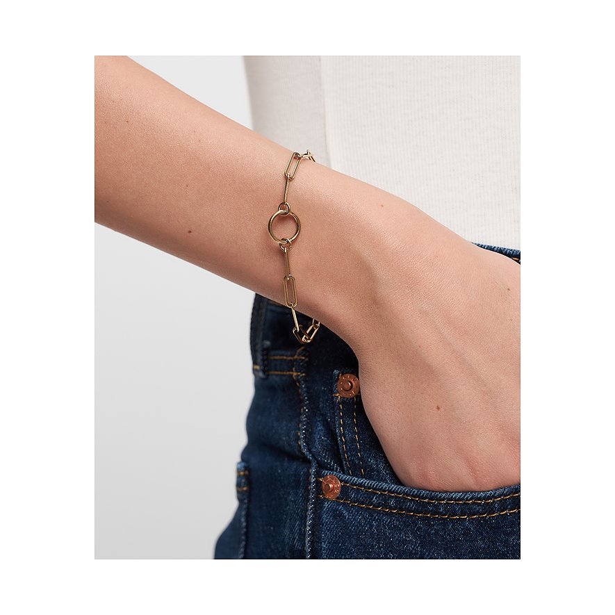 Am Handgelenk getragenes Tamaris Armschmuck aus gelb-goldenem Edelstahl mit länglichen Gliedern und einem Mittelring.