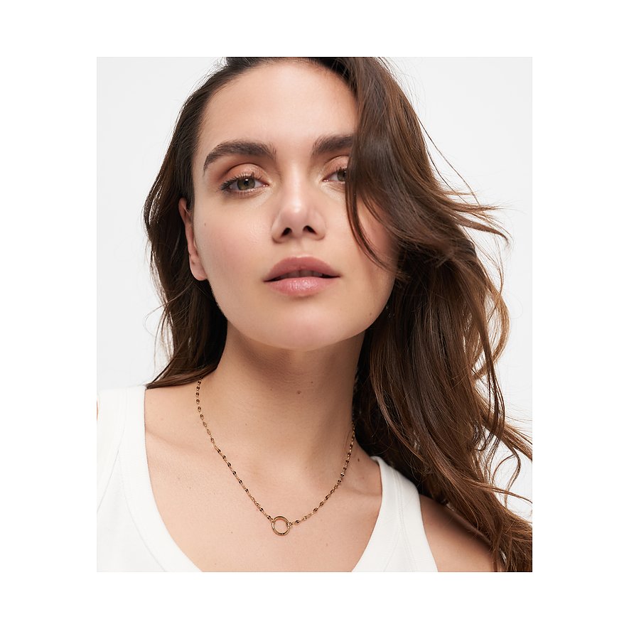 Nahaufnahme eines Modells, das eine feingliedrige, goldene Tamaris Kette aus Edelstahl mit rundem Anhänger trägt.