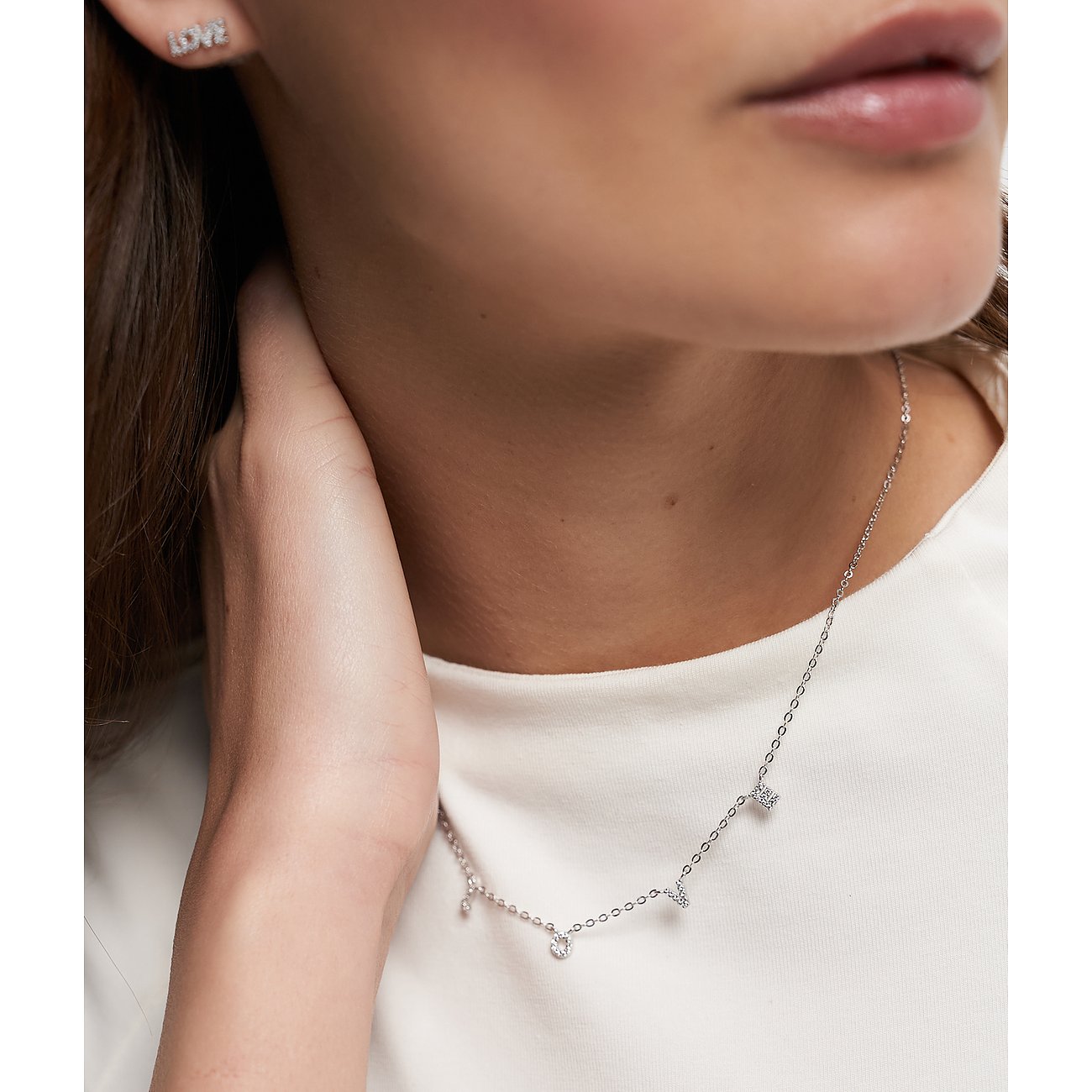 Närbild av kvinna som bär ett Tamaris halsband i 925 silver med flera zirkonia-hängen.