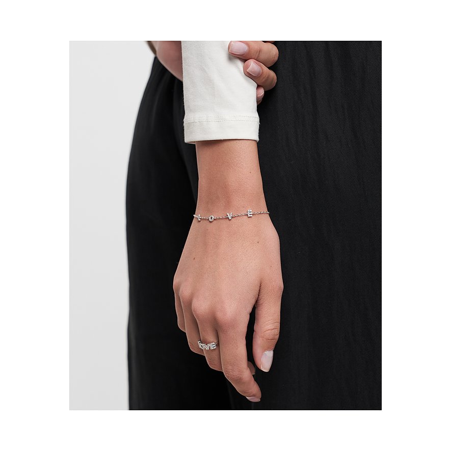 Nahaufnahme eines silberfarbenen Tamaris Armbands mit „LOVE“-Schriftzug und Zirkonia am Handgelenk eines Models.