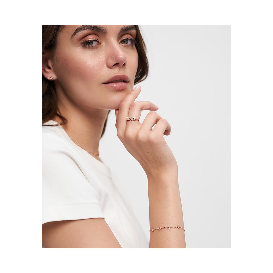 Nahaufnahme eines roségoldenen Silberarmbands mit kleinen „LOVE“-Buchstaben, getragen von einem Model.