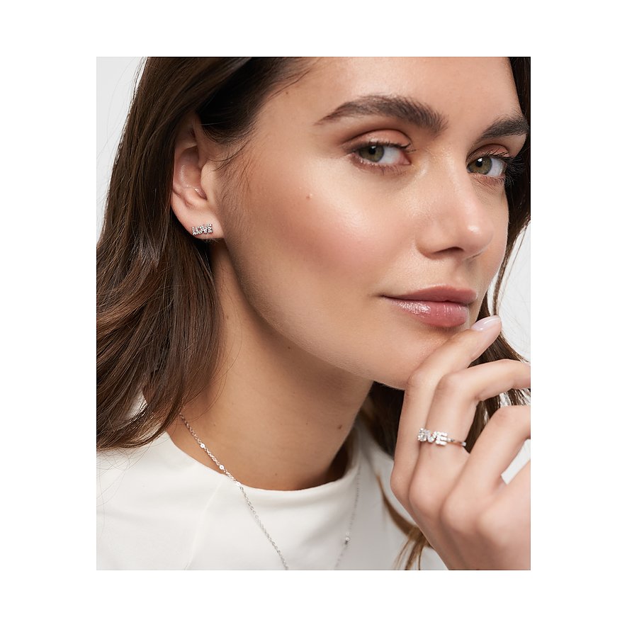 Nahaufnahme einer Frau, die Tamaris Ohrstecker aus 925er Silber mit Zirkonia-Schriftzug „Love“ trägt.