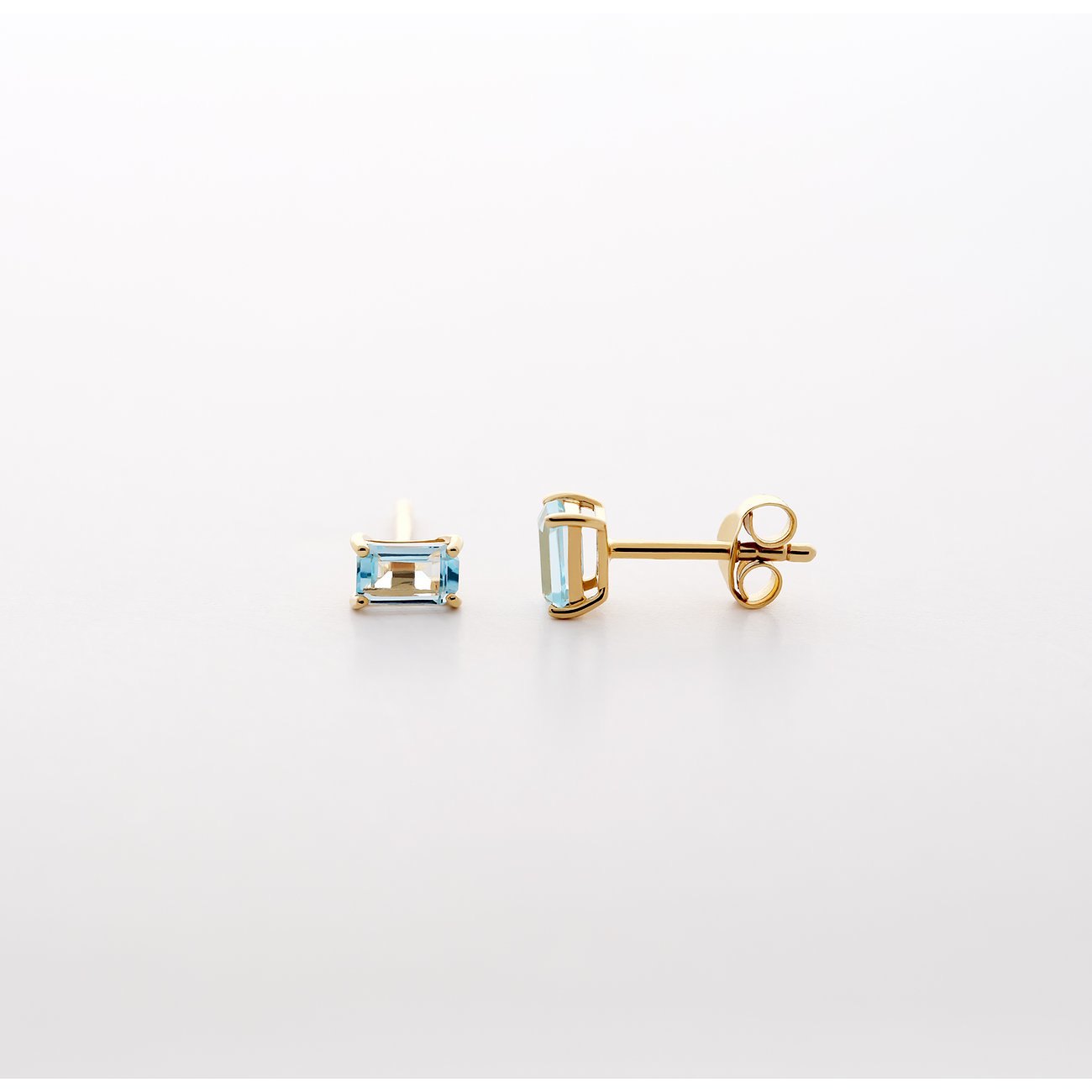 CHRIST Ohrschmuck aus 585 Gelbgold mit facettierten blauen Topas Farbedelsteinen, liegend und aufrecht.