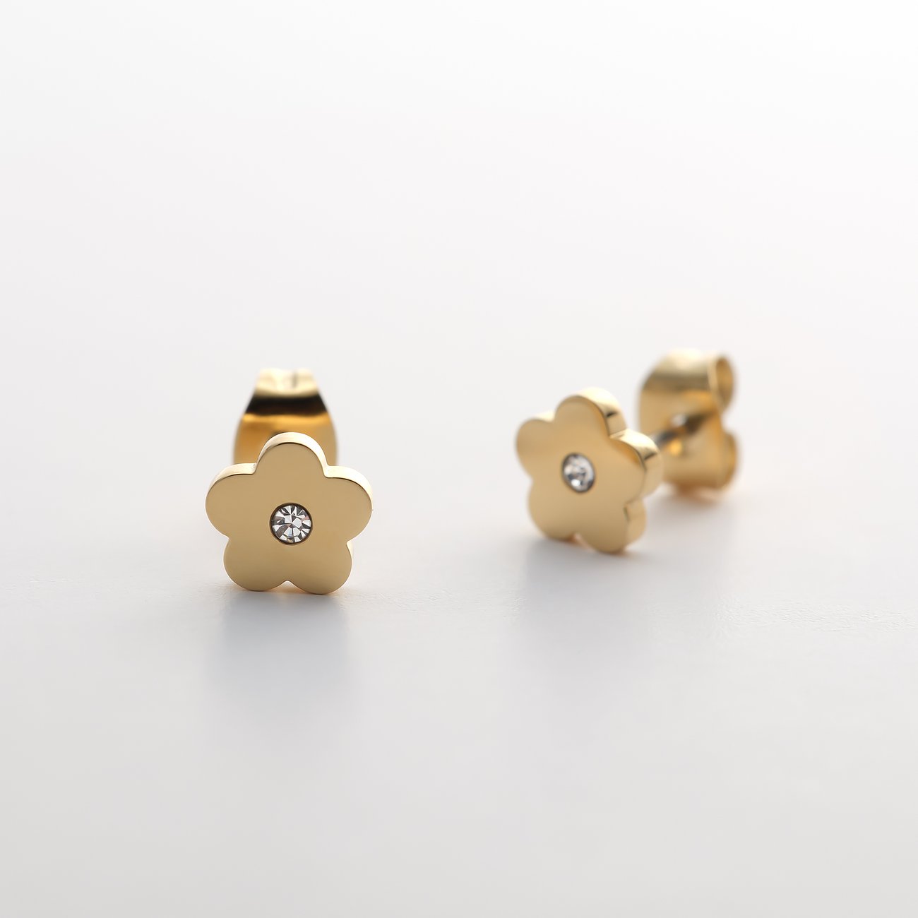 FAVS Little Friends Ohrstecker aus goldfarbenem Edelstahl in Blumenform mit Zirkonia, leicht schräg von vorne.