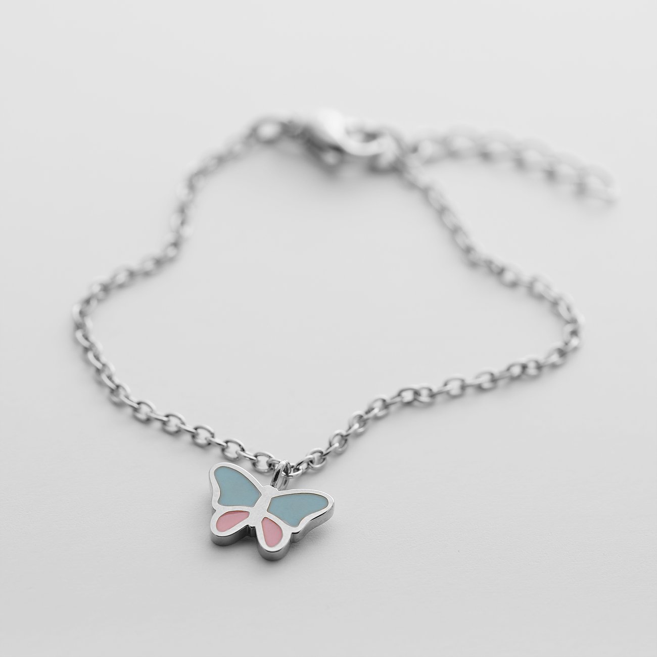 Bracelet FAVS Little Friends en acier inoxydable doré, avec pendentif papillon émaillé bleu et rose.