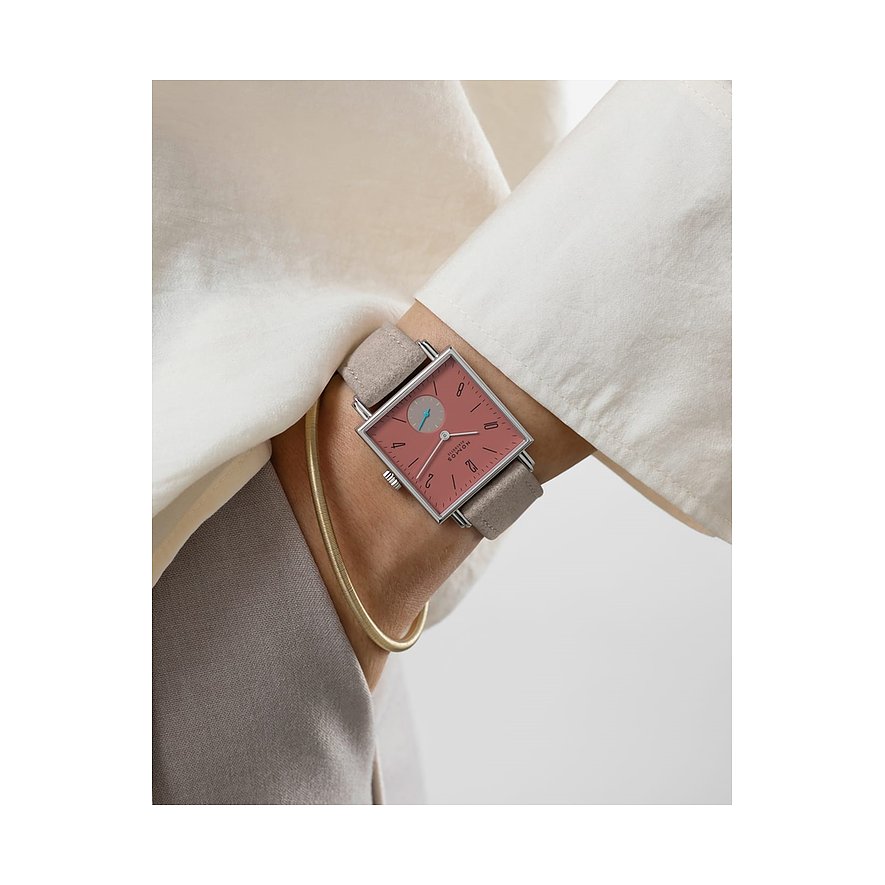 Am Handgelenk getragen, die Nomos Glashütte Damenuhr aus Edelstahl mit quadratischem rosafarbenem Zifferblatt.