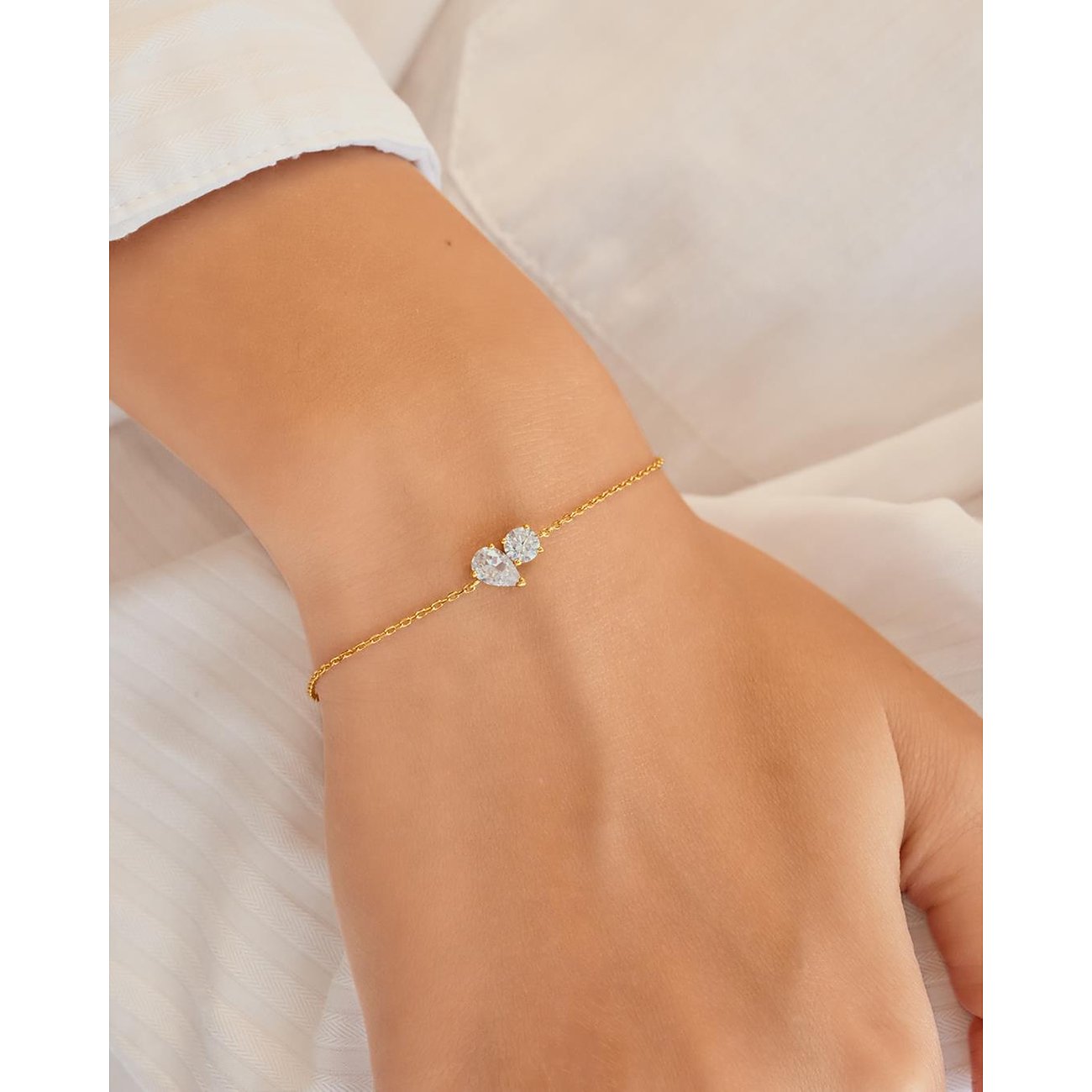 Ania Haie Armband aus vergoldetem Silber mit drei klaren Zirkonia-Schmucksteinen in runder und tropfenförmiger Fassung.