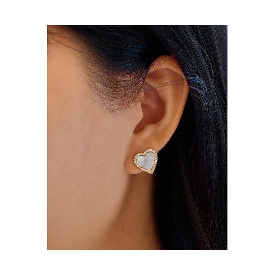 Ania Haie Ohrstecker aus Silber in Herzform mit Zirkonia-Umfassung am Ohr einer Person.