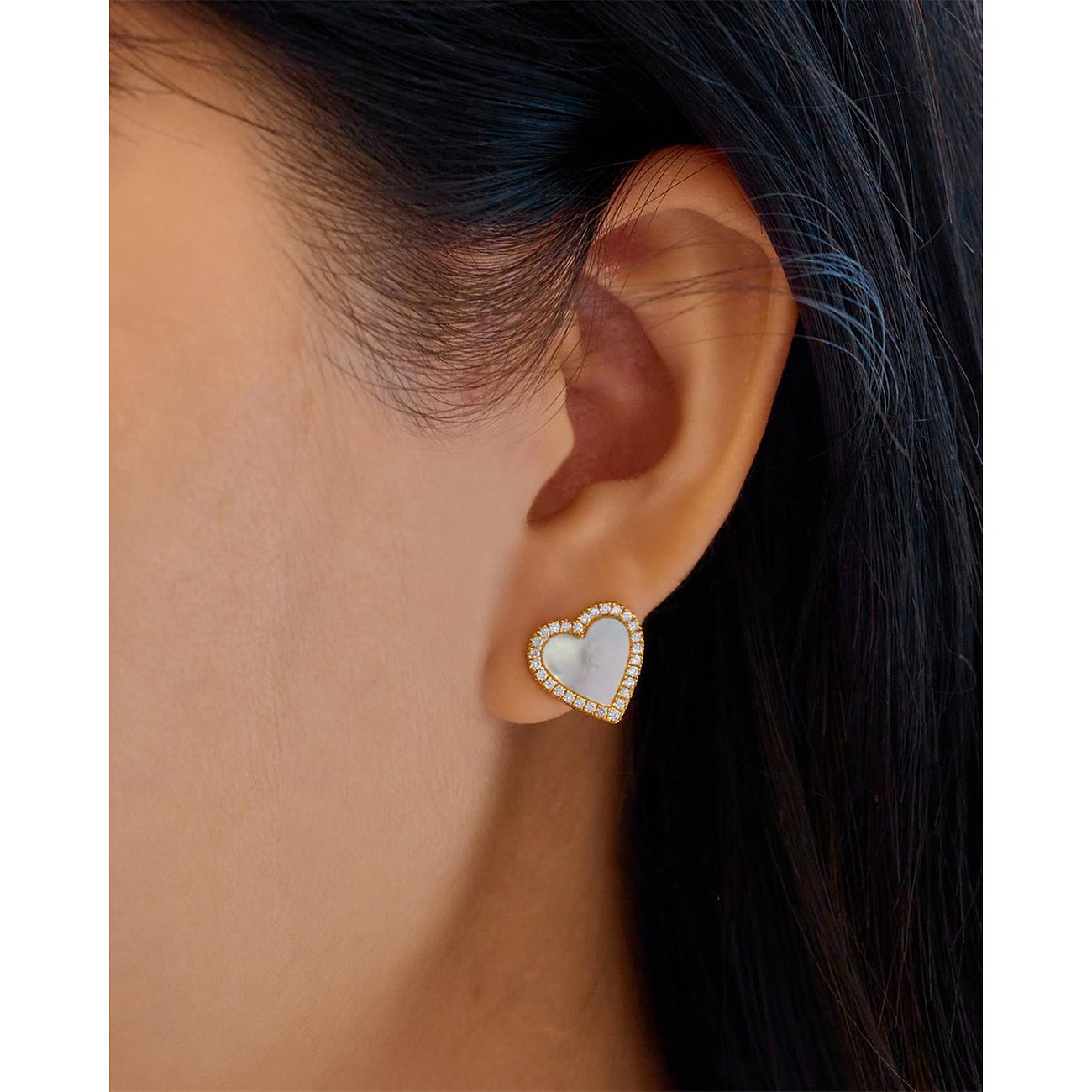 Ania Haie Ohrstecker aus Silber in Herzform mit Zirkonia-Umfassung am Ohr einer Person.