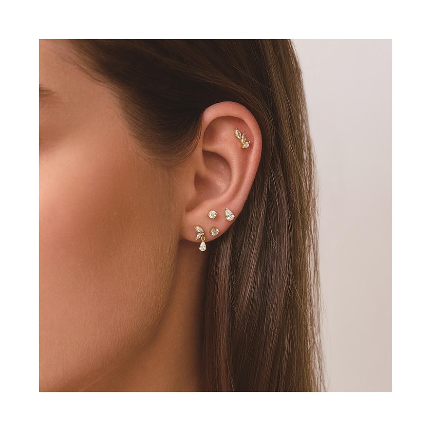 Vrouw draagt Ania Haie zilveren sieraden: bladvormige piercing en oorstekers met zirkonia-druppels.