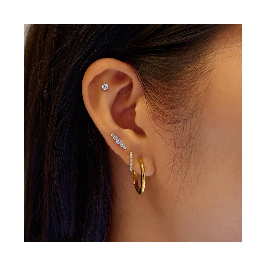 Am Ohr getragenes Ania Haie Ear Cuff aus vergoldetem Silber mit drei Zirkonia als Farbstern.