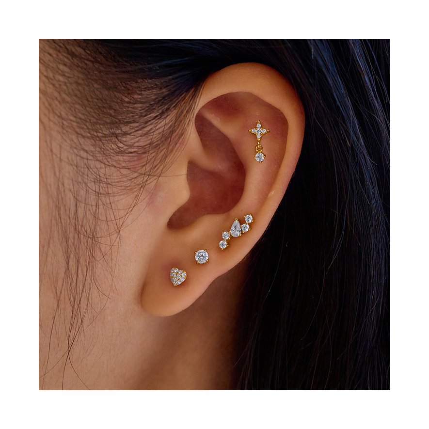 Am Ohr getragenes Ania Haie Ohrschmuck Set aus Silber mit Zirkonia-besetzten Ohrsteckern in Herz-, Kreuz- und Clusterform.