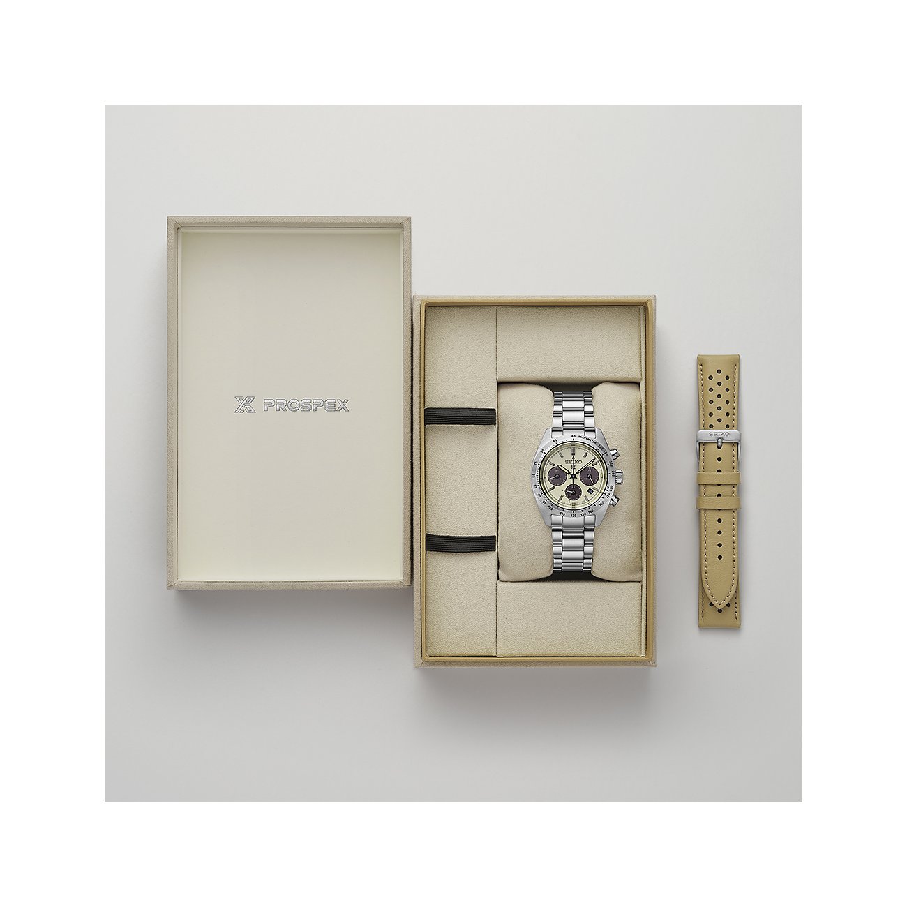 Die Seiko Herrenuhr aus Edelstahl in einer beigen Geschenkbox mit einem zusätzlichen beigen Lederarmband.