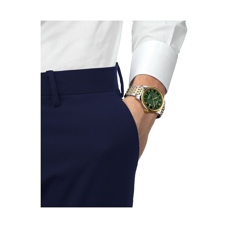 Tissot Herrenuhr aus Edelstahl mit grünem Zifferblatt und goldfarbenem Gehäuse am Handgelenk eines Mannes.