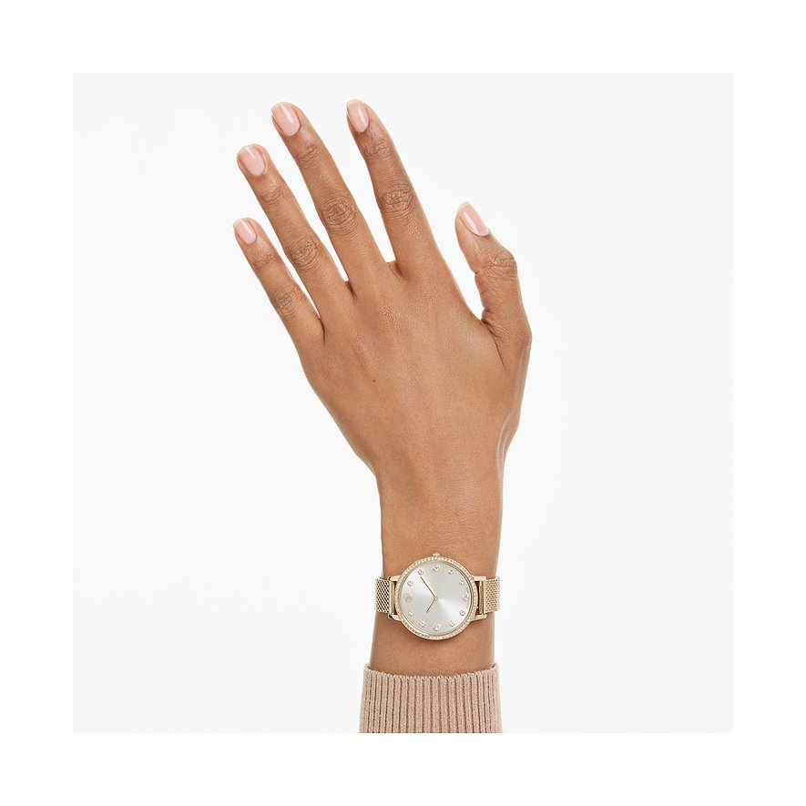 Am Handgelenk getragene goldene Swarovski Unisexuhr aus Edelstahl mit farbigen Kristallen.