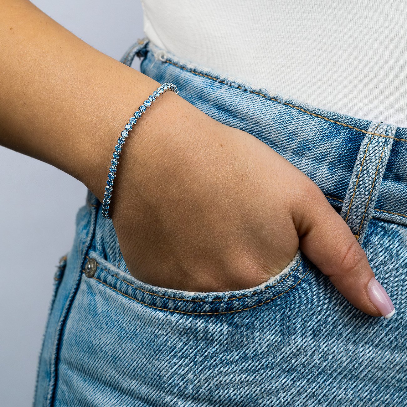 Engelsrufer Armschmuck aus Silber mit blauen Zirkonia Farbsteinen am Handgelenk eines Models.