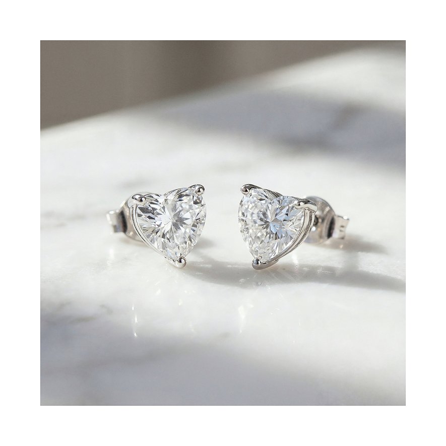 Engelsrufer Ohrstecker aus 925er Silber mit herzförmigen Zirkonia Farbsteinen glitzernd auf einer Oberfläche.