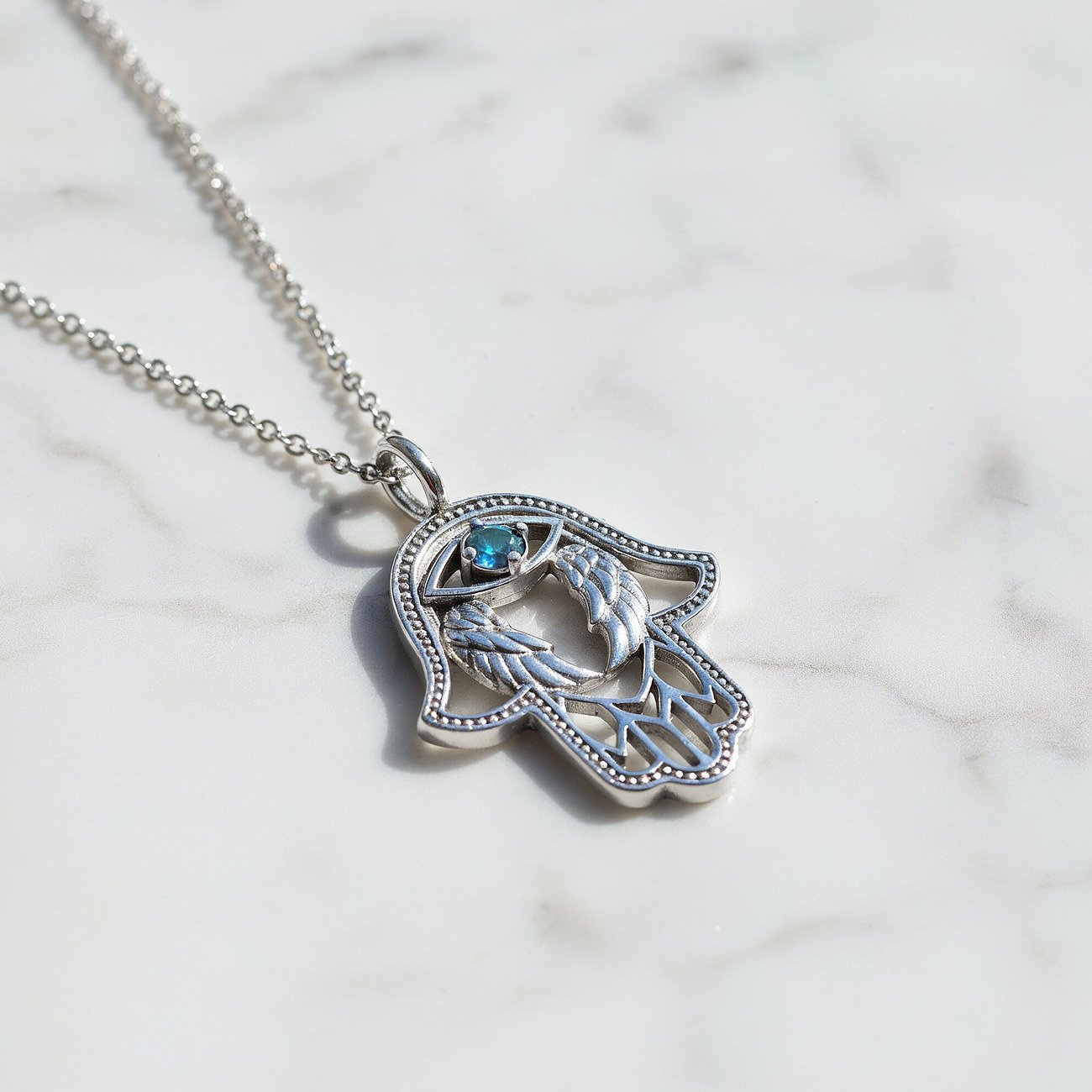 Engelsrufer Fatima Hand Kette aus Sterling Silber mit einem blauen Zirkonia und Engelsflügel-Design.