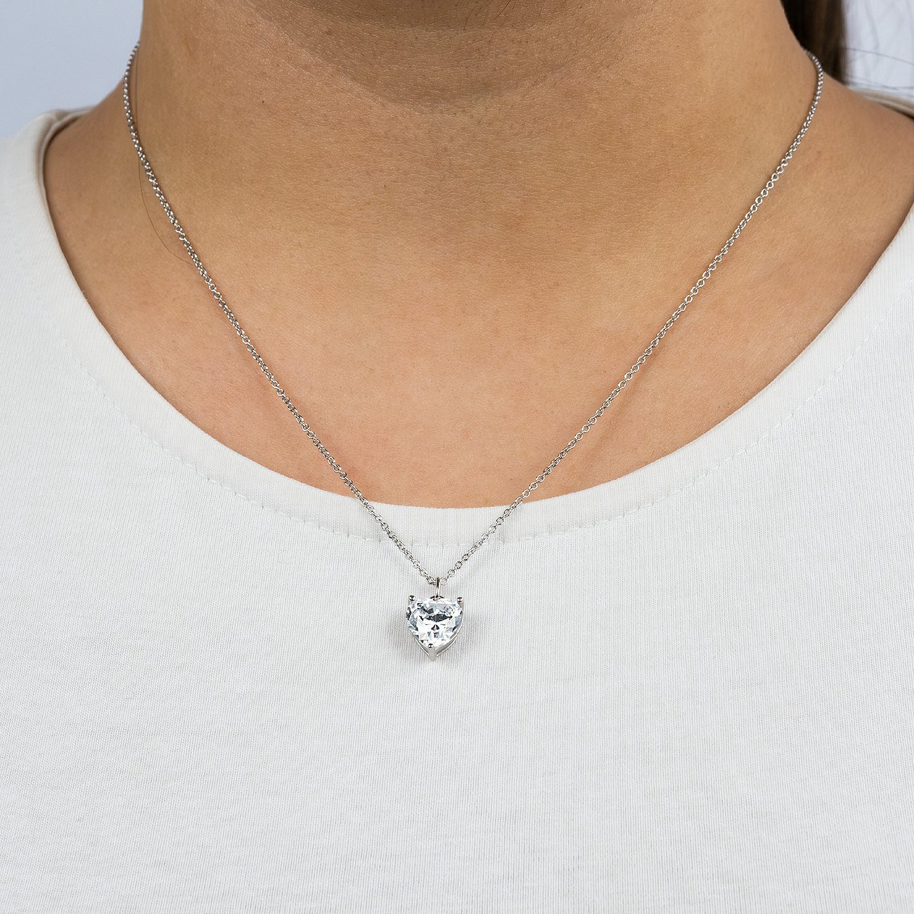 Engelsrufer Halsschmuck aus Silber mit einem herzförmigen weißen Zirkonia-Stein, getragen um den Hals.