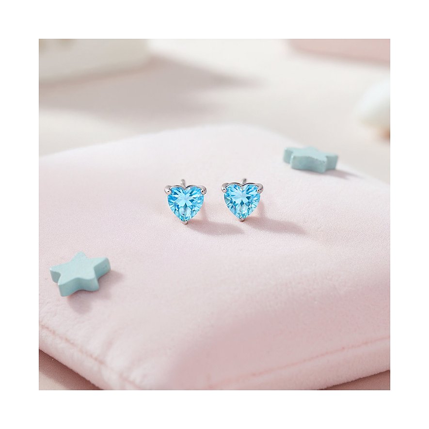 Engelsrufer roestvrijstalen oorknopjes met hartvormige lichtblauwe zirkonia kleurstenen op een roze ondergrond.