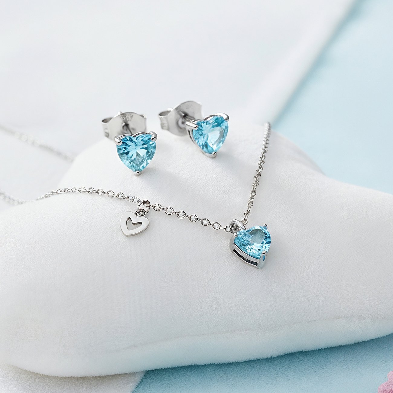 Engelsrufer halssmyckeset: Rostfritt stål hjärthänge och örhängen med blå hjärt-zirkonia som färgsten.