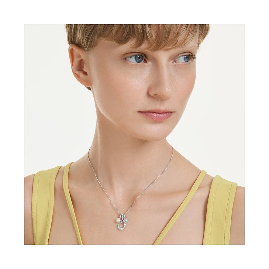 Eine Frau trägt eine Swarovski Halskette aus Metall mit Anhänger, verziert mit einem Farbstein und einem Swarovski-Kristall.