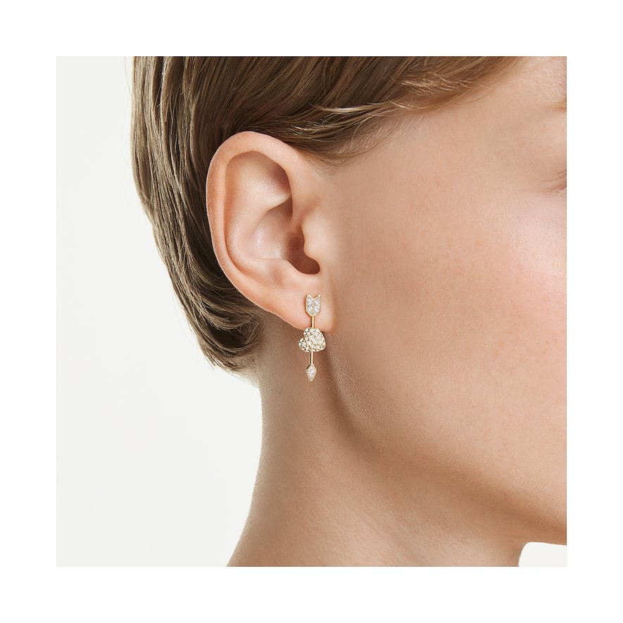 Swarovski-Ohrring aus goldfarbenem Metall mit Schwalbenmotiv, funkelnden Kristallen und Herzanhänger am Ohr.
