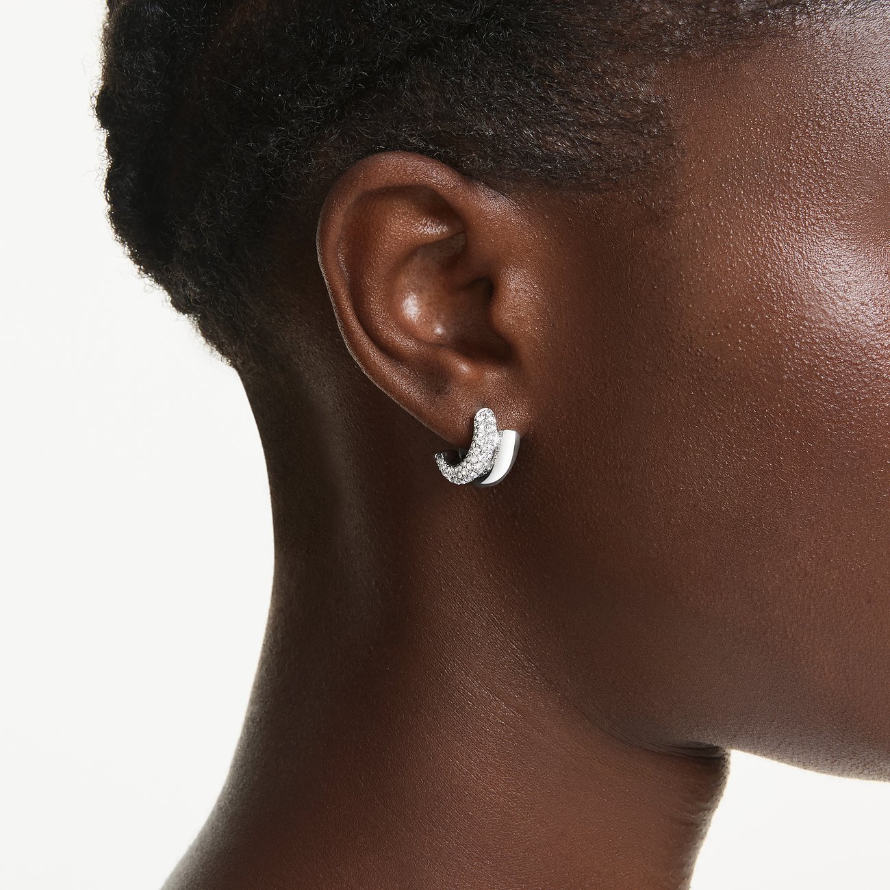Nahaufnahme eines Swarovski Ohrsteckers aus Metall mit funkelnden Swarovski Kristallen am Ohr eines Models.