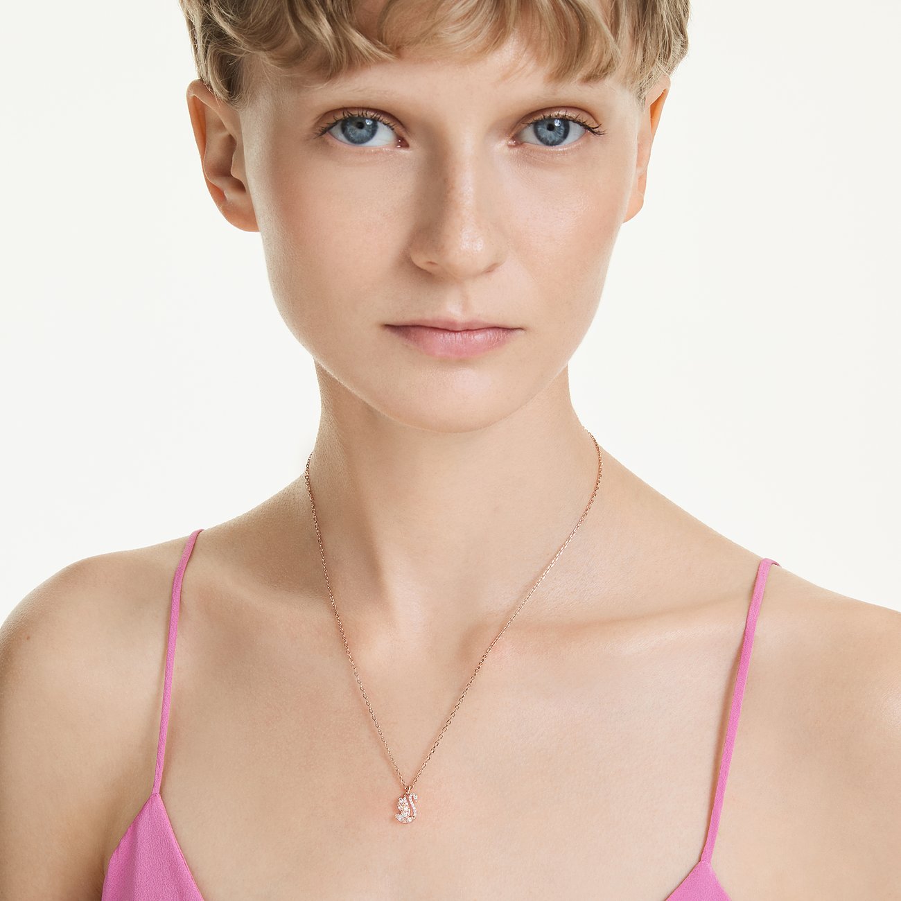 Model trägt eine Swarovski Halskette aus roségoldfarbenem Metall mit einem kleinen, glitzernden Eichhörnchen-Anhänger.