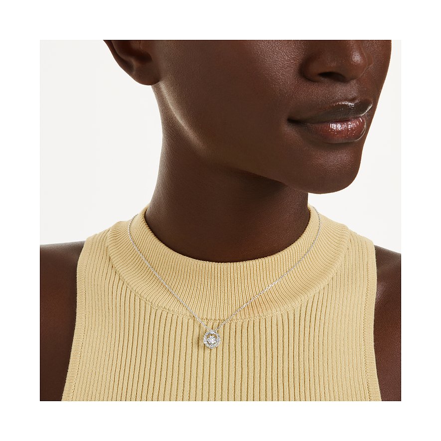 Ein Swarovski Halsschmuck aus Metall mit Swarovski-Kristall hängt um den Hals eines Models, das ein gelbes Oberteil trägt.