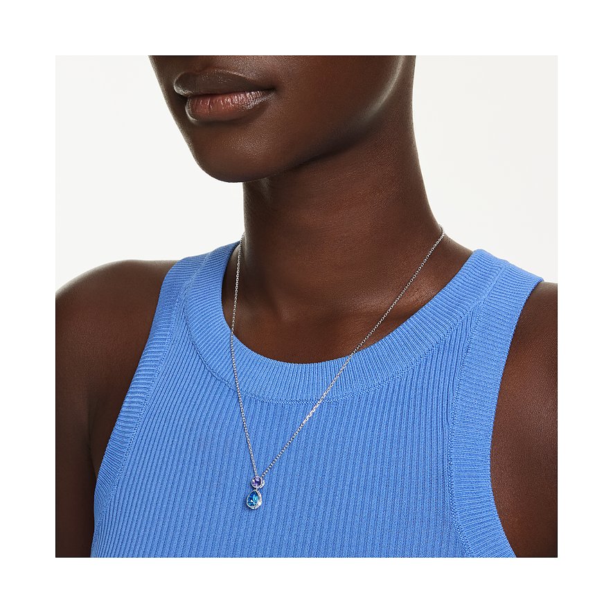 Nahaufnahme einer Person, die eine Swarovski Metall-Halskette mit zwei runden bunten Swarovski-Kristallanhängern trägt.