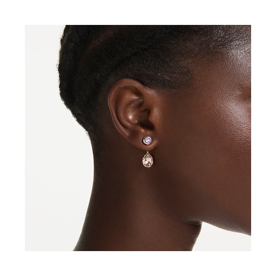 Swarovski oorsieraad van metaal met twee geslepen Swarovski kristallen. De bovenste is paars, de onderste roze.