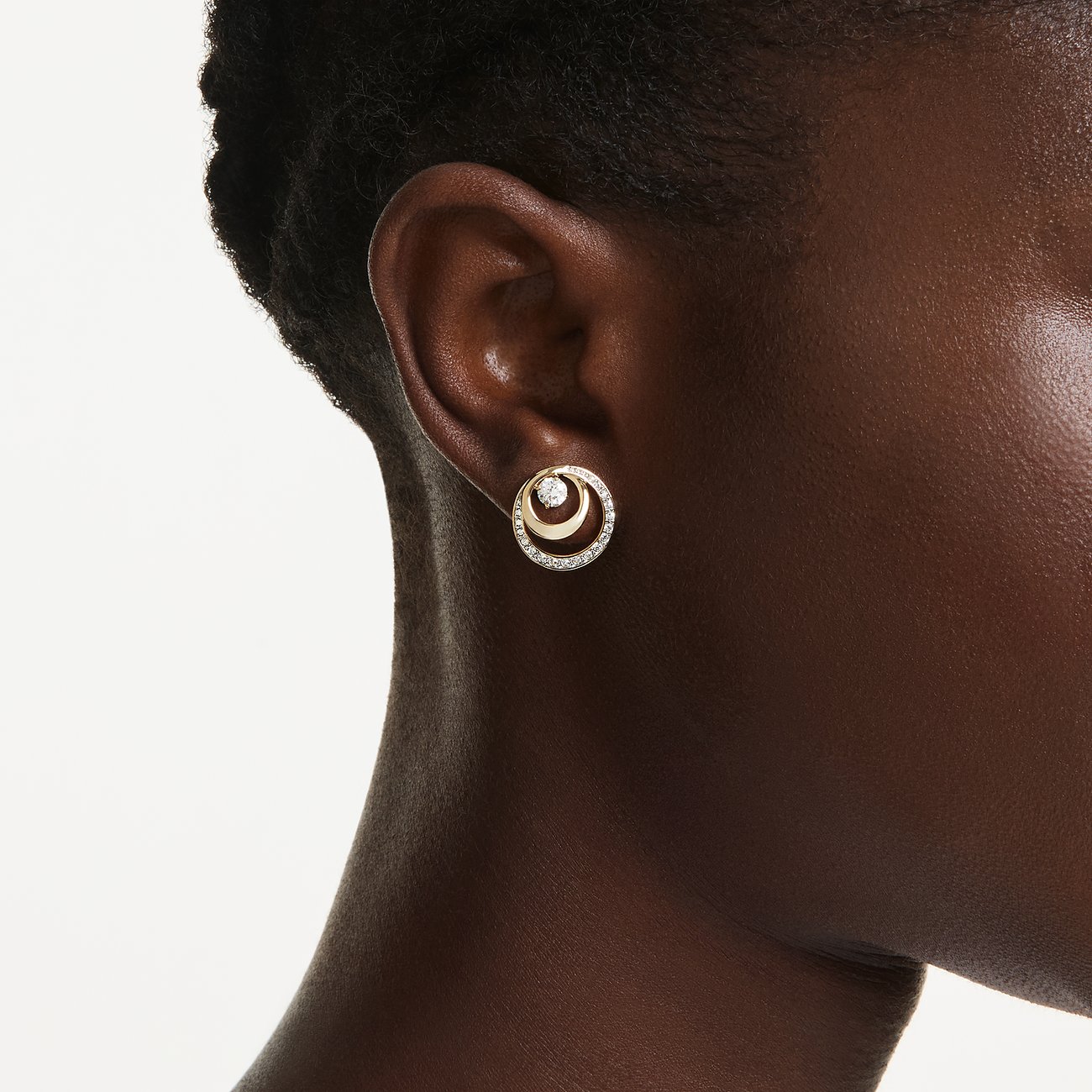 Nahaufnahme eines goldenen Swarovski Ohrschmucks aus Metall mit großen und kleinen ringförmigen Elementen.