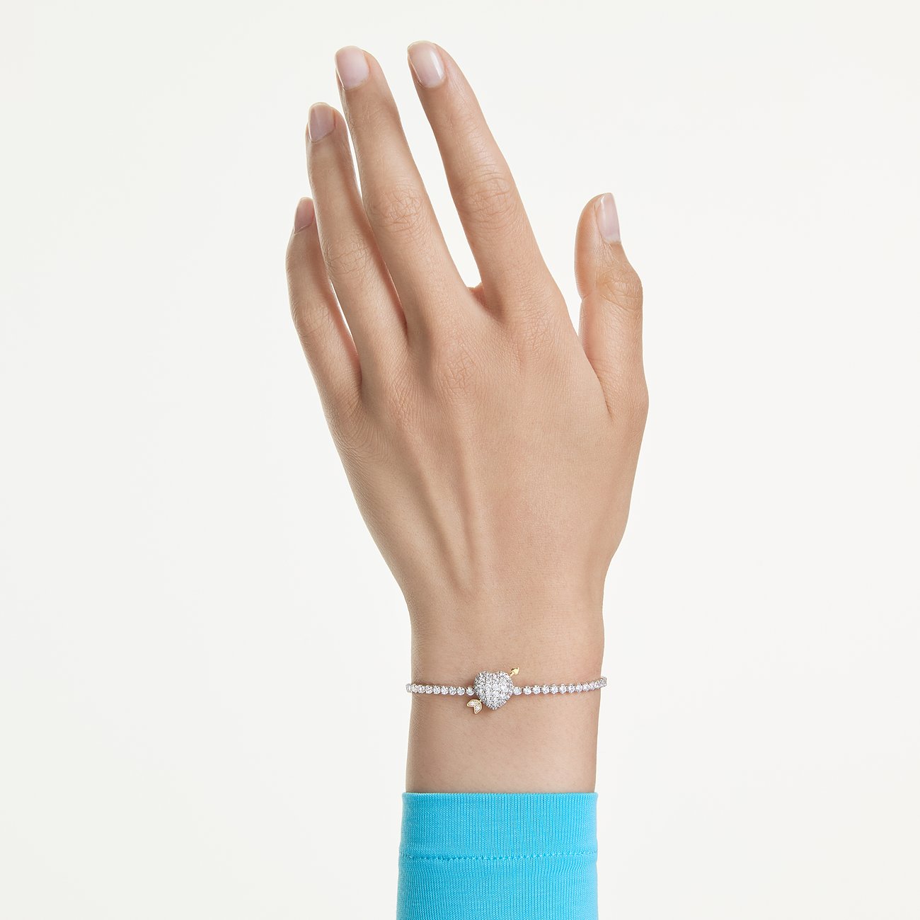 Am Handgelenk getragenes Swarovski Armband aus Metall mit glitzernden Kristallen und einem Herz-Anhänger.