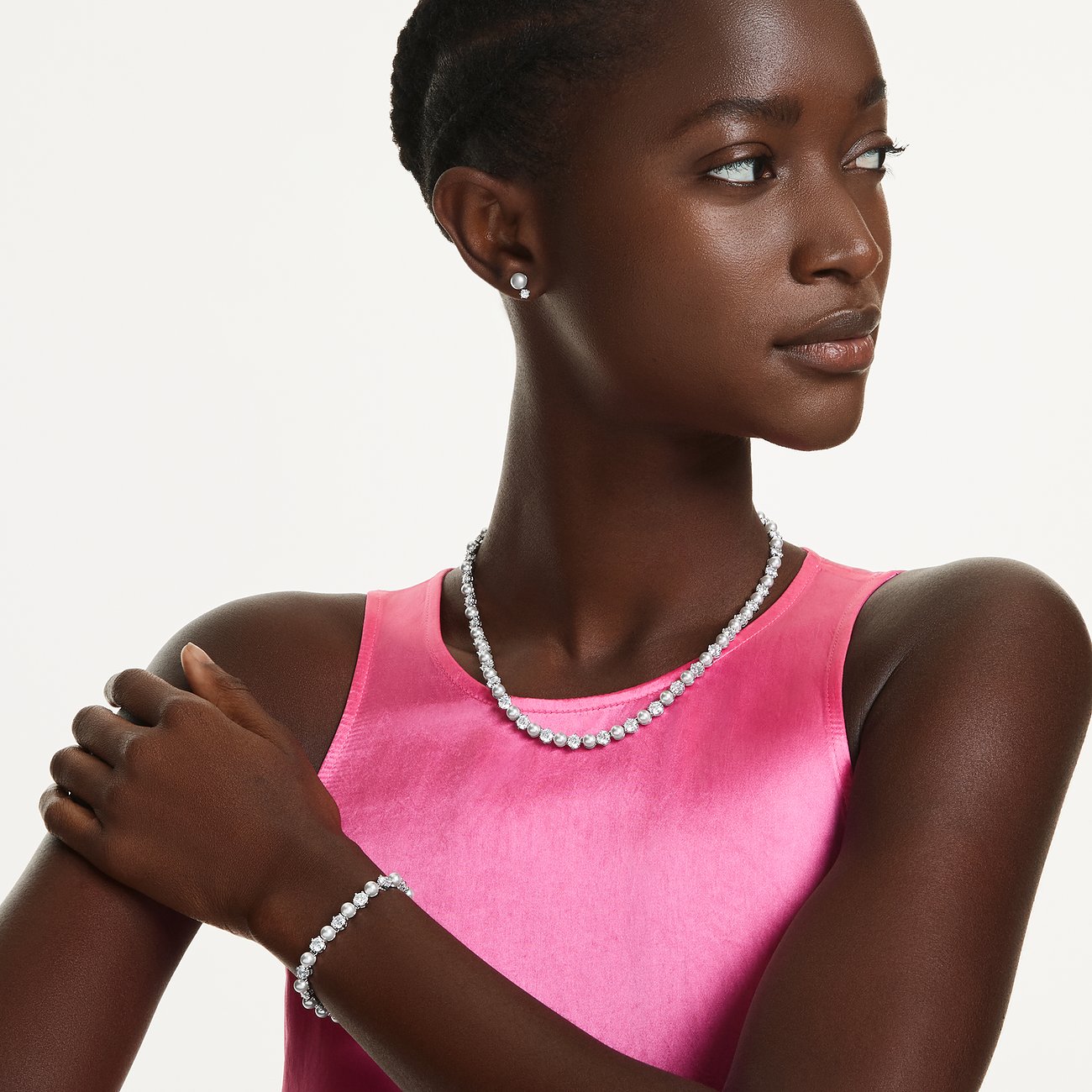 Model trägt Swarovski Schmuckset: Halskette, Armband, Ohrstecker mit funkelnden Kristallen aus Metall.