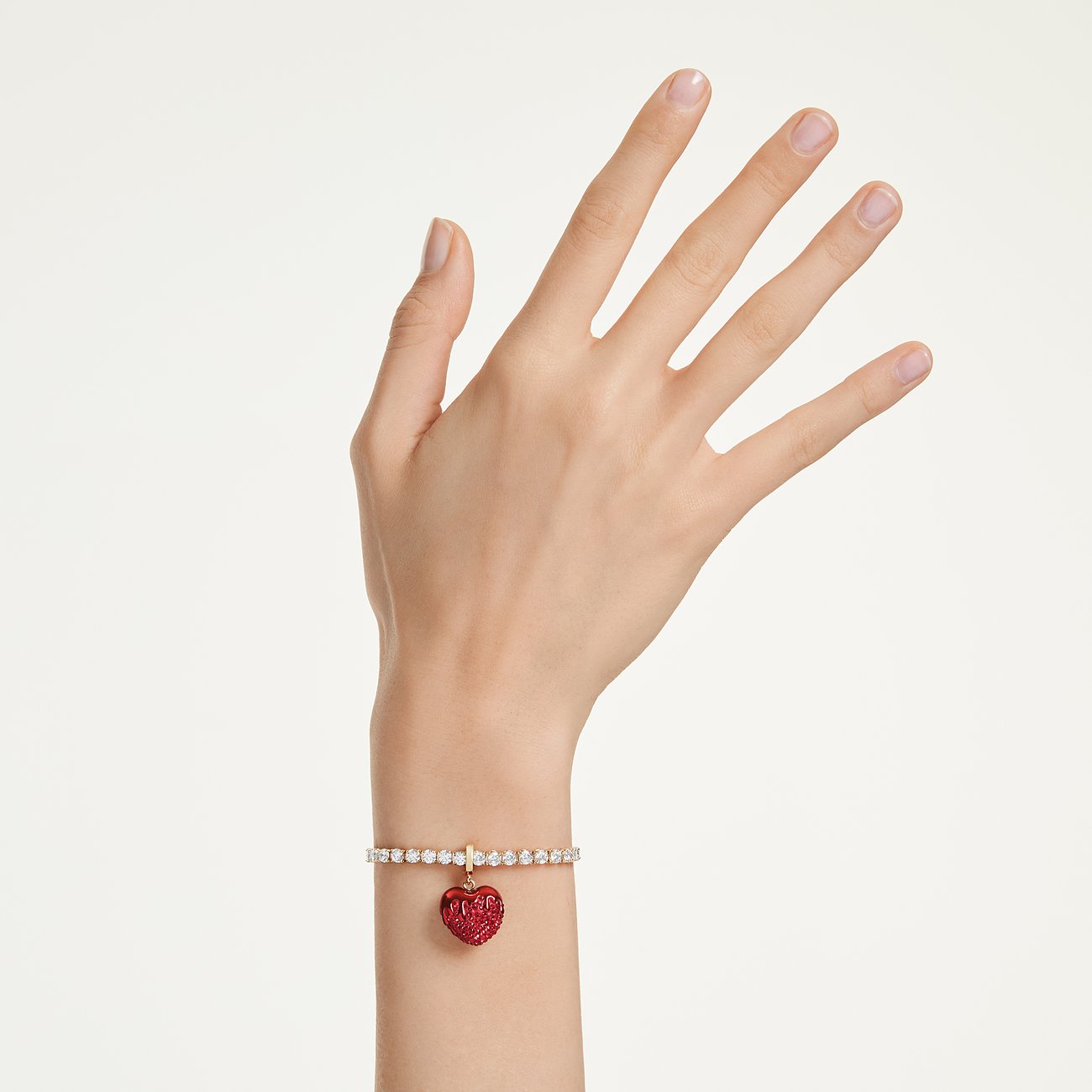 Pols gedragen Swarovski metalen armband met fonkelende Swarovski kristallen en een rode hartvormige hanger.