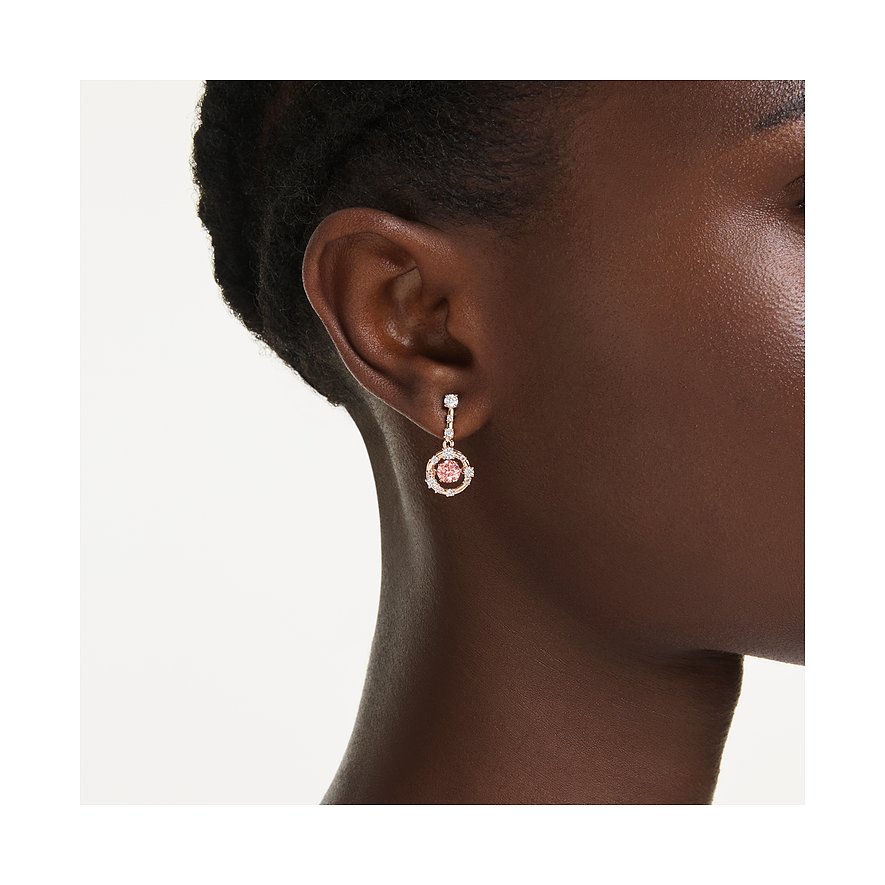 Swarovski Metall-Ohrring mit rundem, rosa Farbkristall, umgeben von kleinen, klaren Swarovski Kristallen, am Ohr.