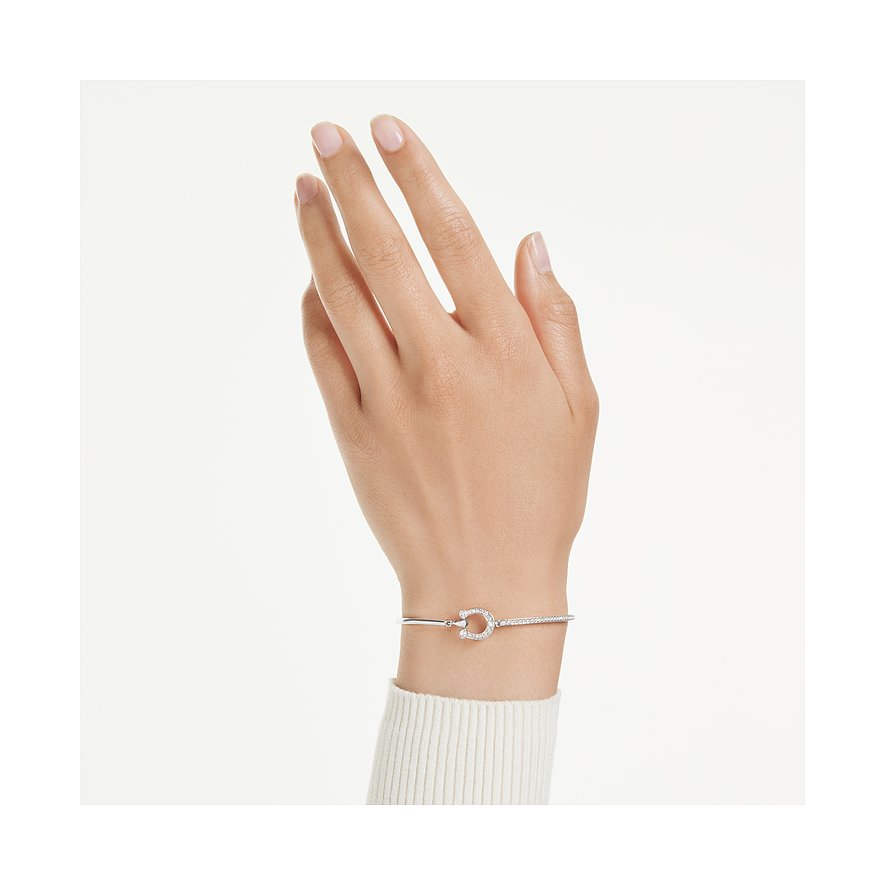 Am Handgelenk getragener Swarovski Armreif aus Metall, verziert mit einem hufeisenförmigen, mit Kristallen besetzten Element.