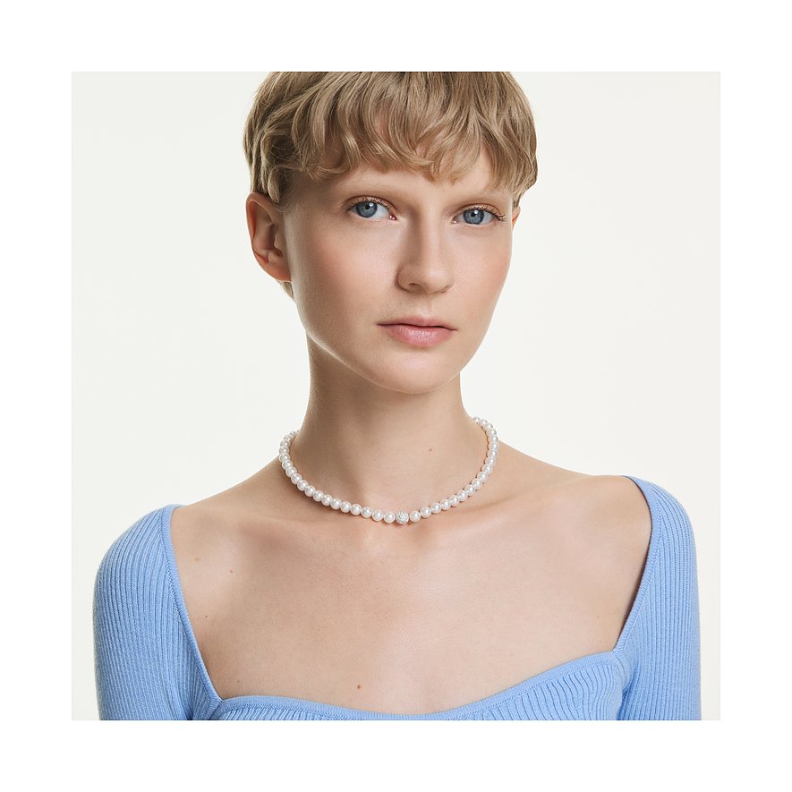 Model draagt een Swarovski ketting met kleine parels en een sprankelende Swarovski kristal in het midden.