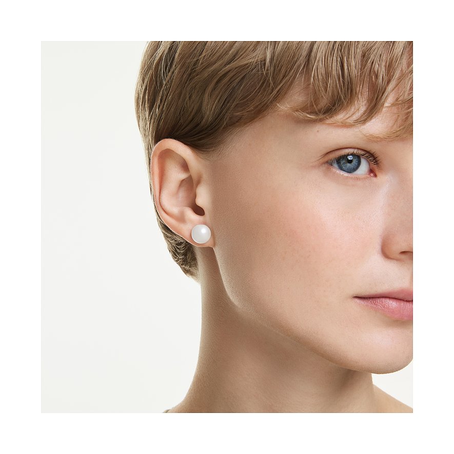Nahaufnahme einer Person mit einem einzelnen runden, weißen Swarovski Ohrstecker aus Metall an einem Ohr.