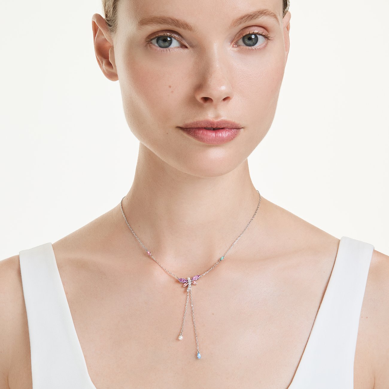 Model draagt een Swarovski metalen ketting met roze, blauwe en paarse vlindervormige kleurstenen.