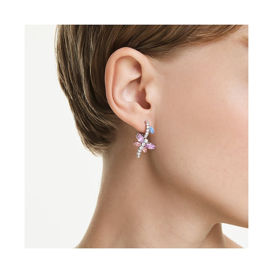 Swarovski Ohrring aus Metall mit rosa, lila und blauen Schmetterlings-Kristallen am Ohr einer Person.