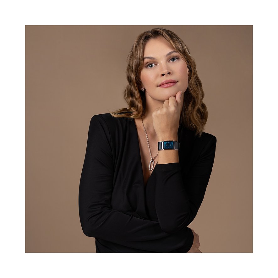 Ein Model trägt eine rechteckige Jacques Lemans Damenuhr aus Edelstahl mit blauem Zifferblatt am Handgelenk.