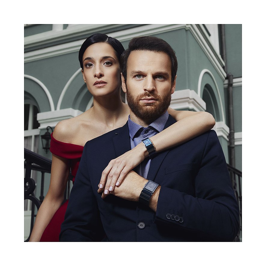 Model trägt eine rechteckige Jacques Lemans Damenuhr aus Edelstahl mit einem dunklen Zifferblatt.