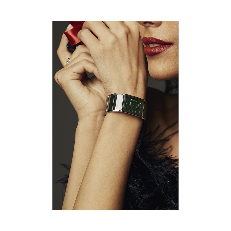 Nahaufnahme einer Jacques Lemans Damenuhr aus Edelstahl mit rechteckigem grünen Zifferblatt am Handgelenk einer Frau.