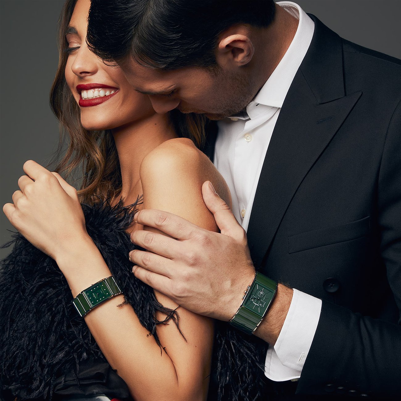 Ein lächelndes Paar trägt Armbänder von Jacques Lemans. Die Frau trägt eine Damenuhr aus Edelstahl mit grünem Zifferblatt