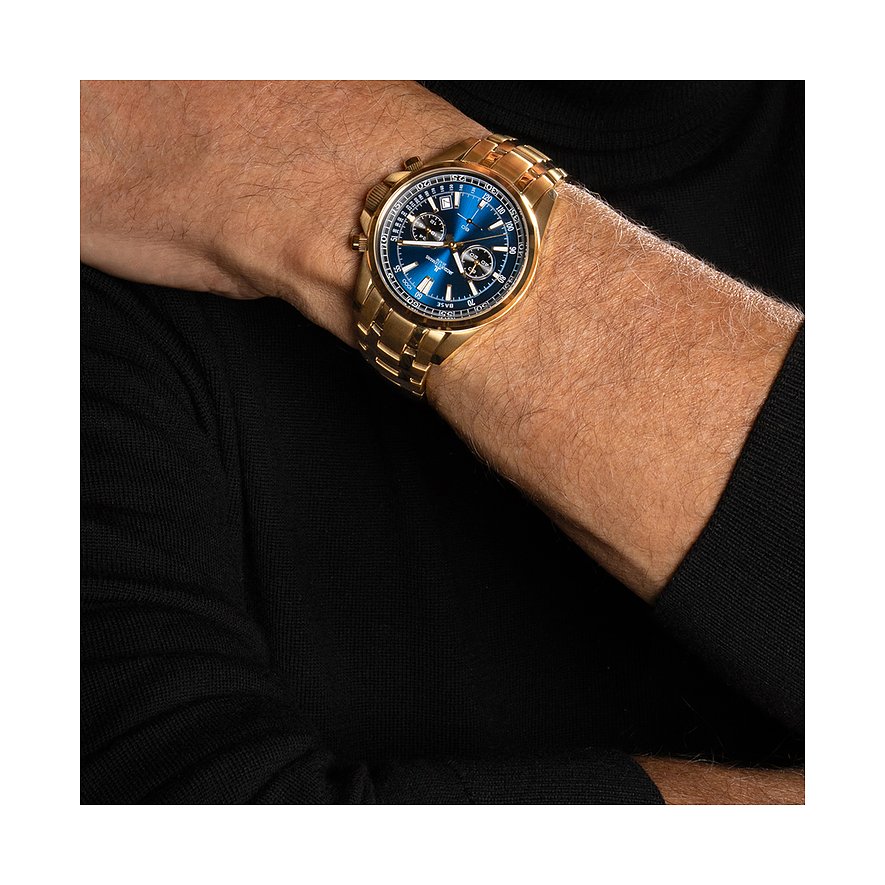 Jacques Lemans Herrenuhr aus blauem und goldenem Edelstahl am Handgelenk eines Mannes mit schwarzem Rollkragenpullover.